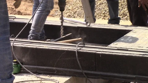 Construction worker drills a hole with a drill to work with tram rails Stock Footage 116318578