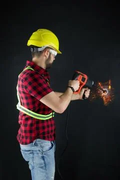 Construction Worker drills with a large demolition hammer  on black background. Stock Photos