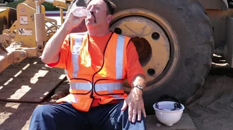 Construction worker drinks from plastic water bottle on hot day Stock Footage 11809765