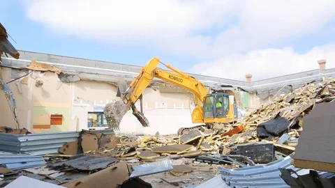 Construction worker drives controls heavy equipment at demolition site B Stock Footage 125055522