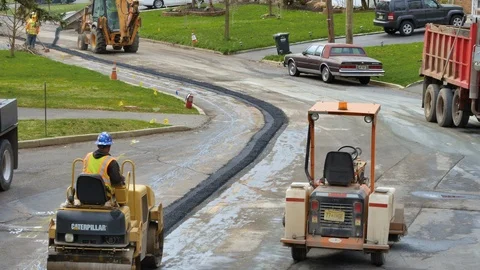 Construction worker driving asphalt roller wide shot Stock Footage 106364987