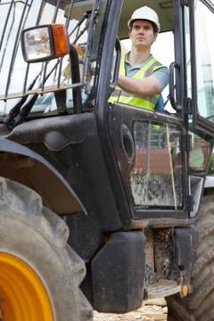 Construction worker driving digger Foto stock