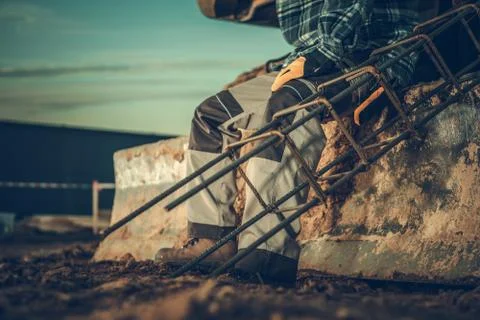 Construction Worker with Element of Building Steel Reinforcement in a Hand. Fotos de archivo