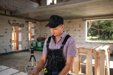 Construction worker engineer at construction site measures the length of wind Stockfoto's