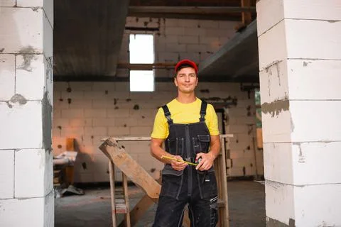 Construction worker engineer at construction site measures the length of wind Foto stock