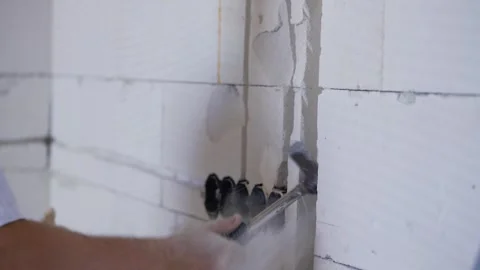 Construction worker expanding electric cable chase grooves with wall chisel.. Stock Footage 301405552