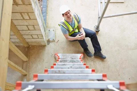 Construction worker falling off ladder and injuring leg Foto stock
