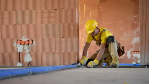 Construction Worker Finishing Interior Electric Floor Installations Stock Footage 141034101