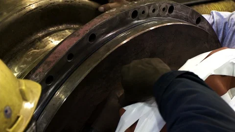 Construction worker fitting large metal object with hook for crane Stock Footage 123728308