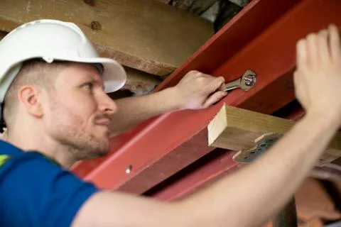 Construction Worker Fitting Steel Support Beam Into Renovated House Ceiling Stock Photos