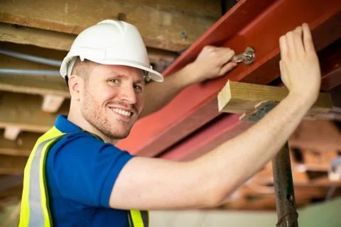 Construction Worker Fitting Steel Support Beam Into Renovated House Ceiling Stock Photos