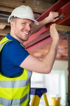 Construction Worker Fitting Steel Support Beam Into Renovated House Ceiling Stock Photos