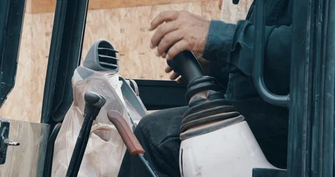 Construction worker in front loader machine controlling joysticks on work site Video stock 118993522