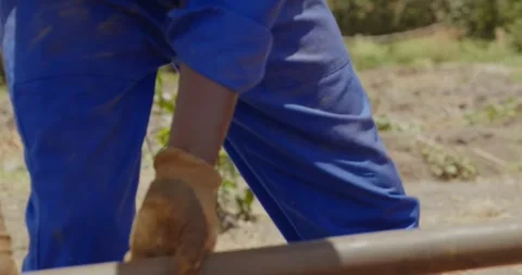 Construction worker in gloves and a blue uniform operates a manual drilling Stock Footage 294313345