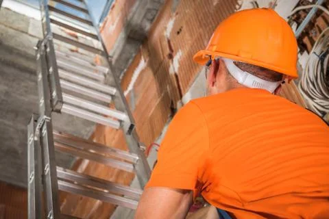 Construction Worker Going Upstairs Using Aluminium Ladder Foto stock