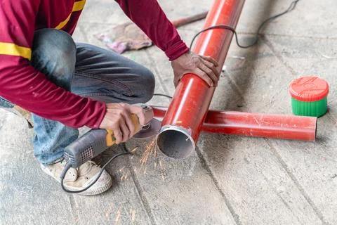 Construction worker grinding a end pipe Stock Photos