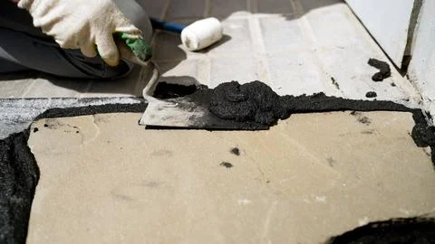 Construction worker grouting irregular paving stones Stock Photos