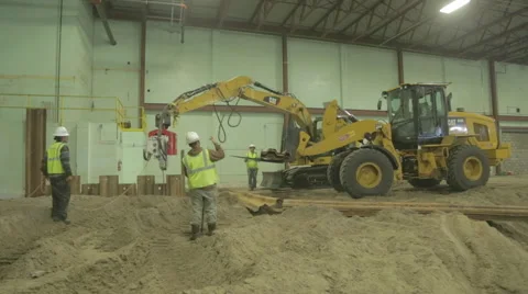 Construction Worker Guiding Yellow Loader On Construction site Stock Footage 46589569