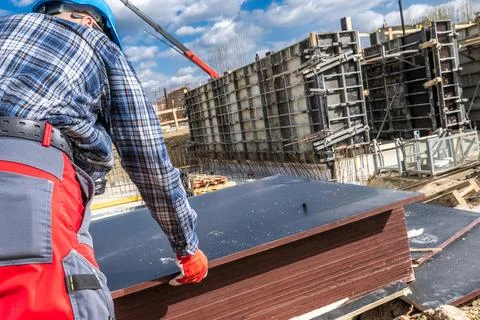 Construction Worker Handling Materials at a Building Site in Spring Photos