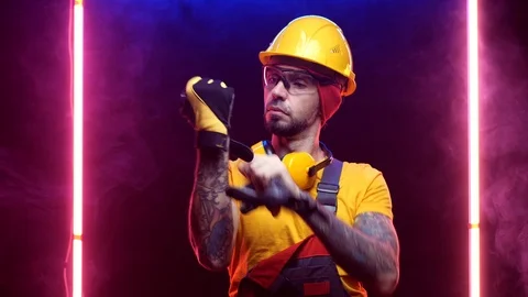 A construction worker in a hard hat puts on gloves Stock Footage 125926338