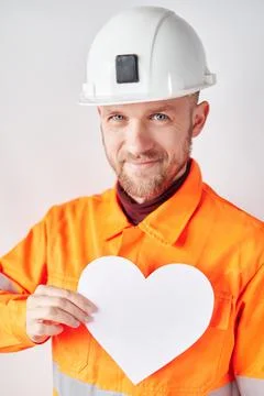 Construction worker in hard hat with white paper heart 库存照片