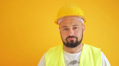 Construction worker in a hard hat on a yellow background Stock Footage 201625710