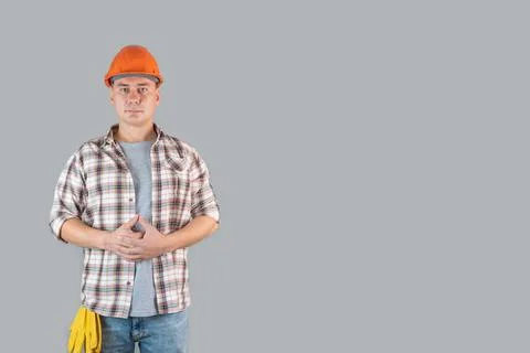 Construction worker in hardhat on gray background, copyspace Foto stock