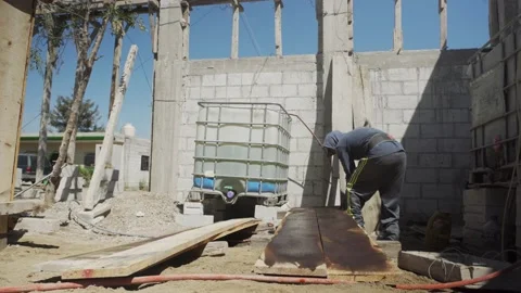 Construction worker in hardhat holding up plank at site 스톡 동영상 232083321