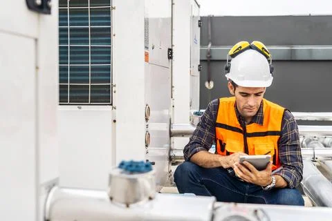 Construction worker in a hardhat using a digital tablet while sitting 写真素材