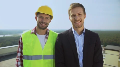 Construction worker in helmet and director smiling on camera, professional team 動画素材 117217645
