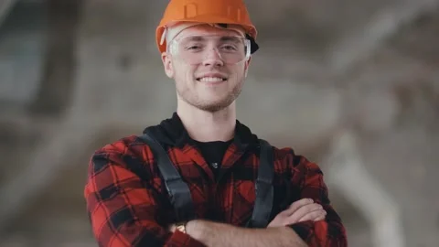Construction worker in a helmet and safety glasses dressed in overalls. Portrait Video stock 130775600