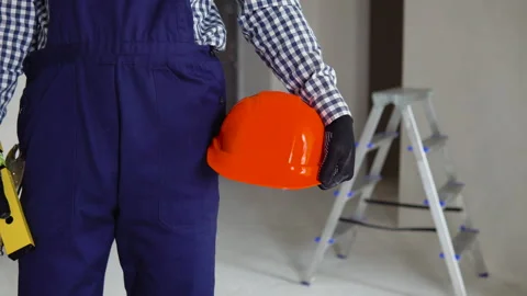 Construction worker with helmet and waterpas at construction site. Repair in an Stock Footage 237760351