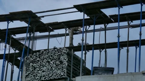 Construction worker on high scaffolding stacking metal supports Stock Footage 320462292