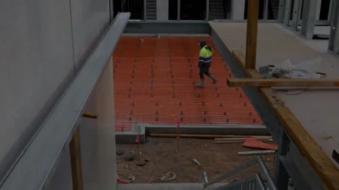 Construction worker in high vis jacket walking slab prep building site Stock Footage 305107668
