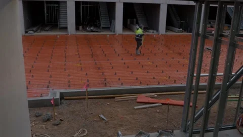 Construction worker in high vis jacket carrying shovel on building site Stock Footage 305107702