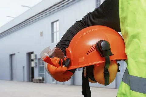Construction worker in high visibility vest holding orange hard hat with head Stock Photos