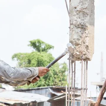 Construction worker hitting movement remove concrete pole with hammer Stock Photos