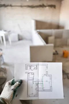 The construction worker hold in hands Architectural blueprints. Repair or Stock Photos