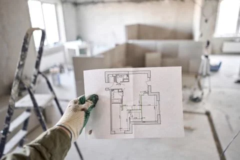 The construction worker hold in hands Architectural blueprints. Repair or Foto stock