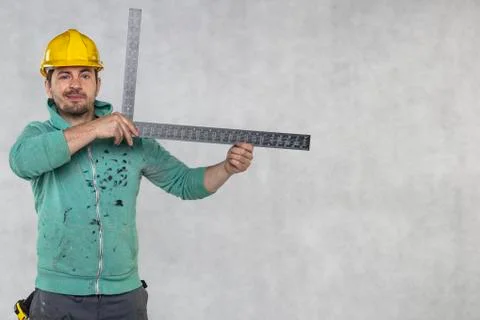 The construction worker is holding a angle in the hand, a guide to constructi Stock Photos