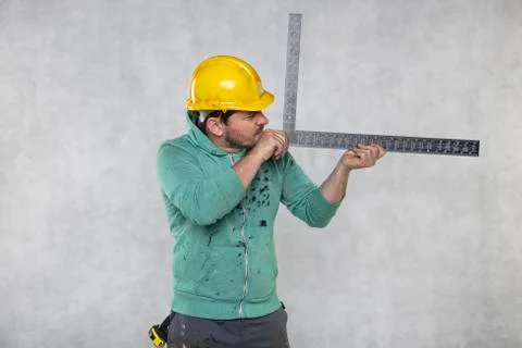 The construction worker is holding a angle in the hand, a guide to constructi Stock Photos