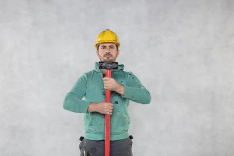 The construction worker is holding a hammer, ready for demolition tasks Stock Photos