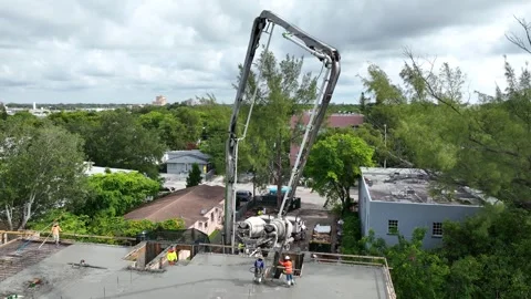 Construction worker holding pump hose for pouring liquid cement on surface with Stock Footage 245959831