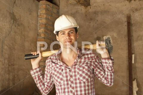 A construction worker holding a sledgehammer Stock Photos