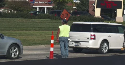 Construction Worker Holding a SLOW Sign Stock Footage 78554623