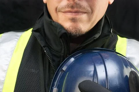 Construction worker holds hard hat to chest Stock Photos