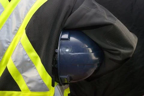 Construction worker holds hard hat under arm Stock Photos