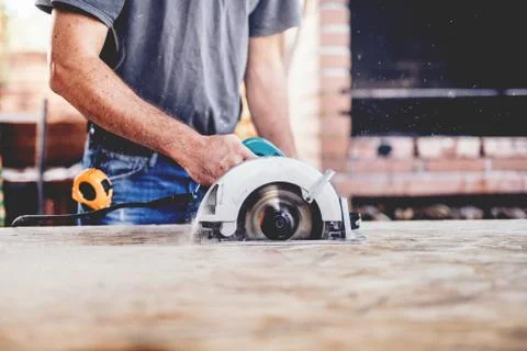 Construction worker, industrial carpenter using circular miter saw Stock Photos