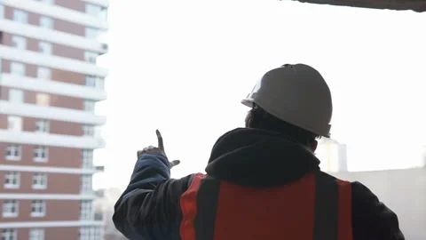 A construction worker inspects the building from a bird's eye view. Stock Footage 131843061