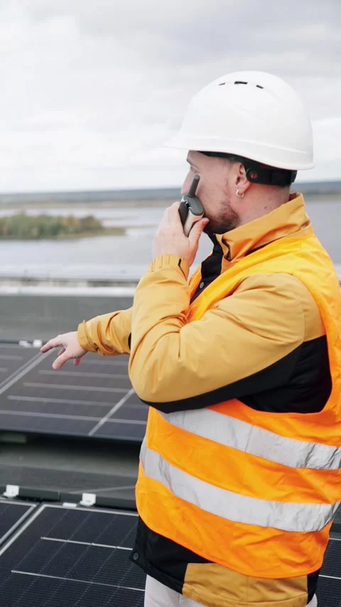 A construction worker inspects solar panels using a walkie-talkie. Video stock 331518465